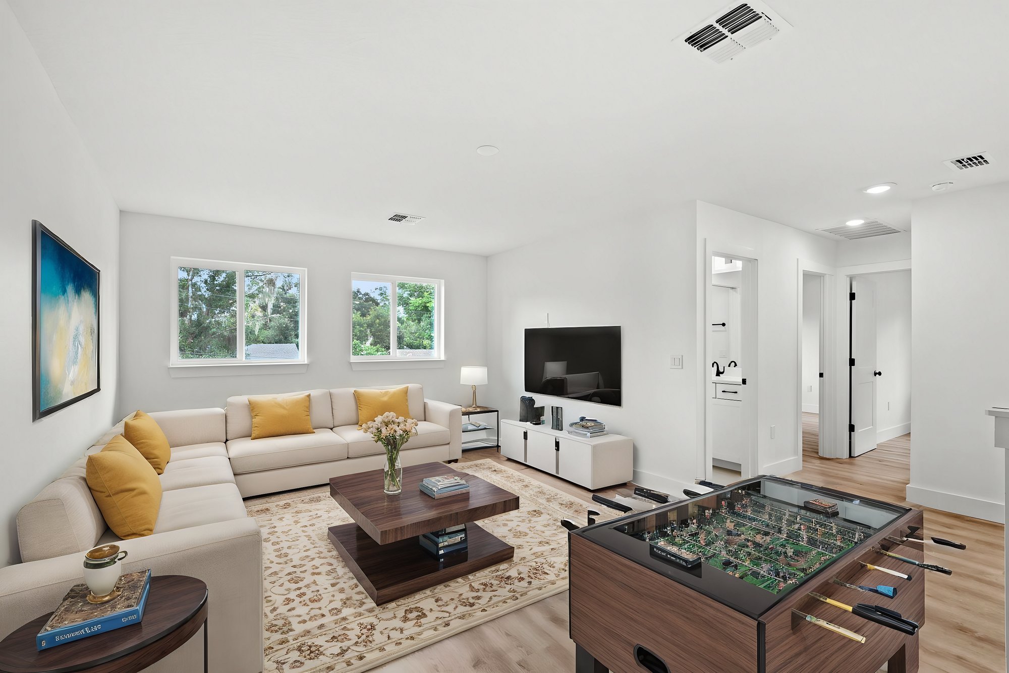 loft with sectional and tv with foosball table